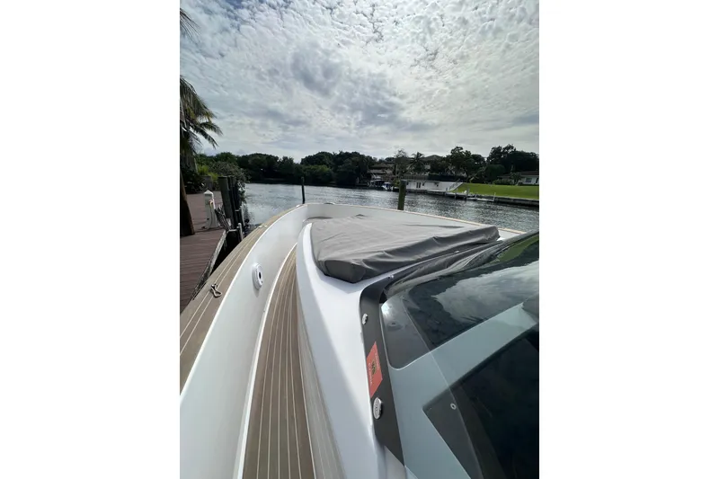 Slide: The Image of 2024 Pardo Yachts P38 docked by a scenic waterfront under a cloudy sky. - 7