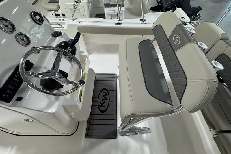 Slide: The Image of 2026 Key West 189 FS boat interior with steering wheel and cushioned seating. - 12