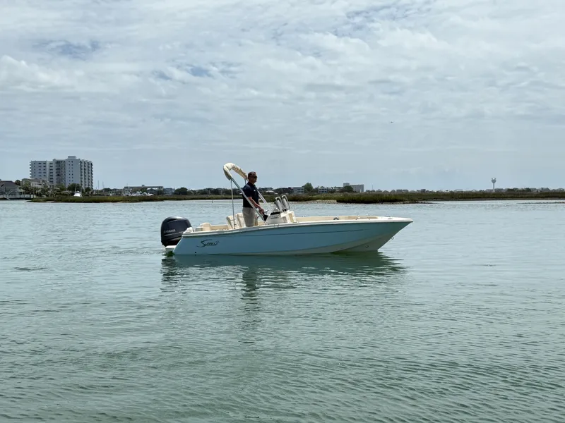Slide: The Image of Scout 188 Sport Dorado 2026 on calm water with cityscape in background. - 0