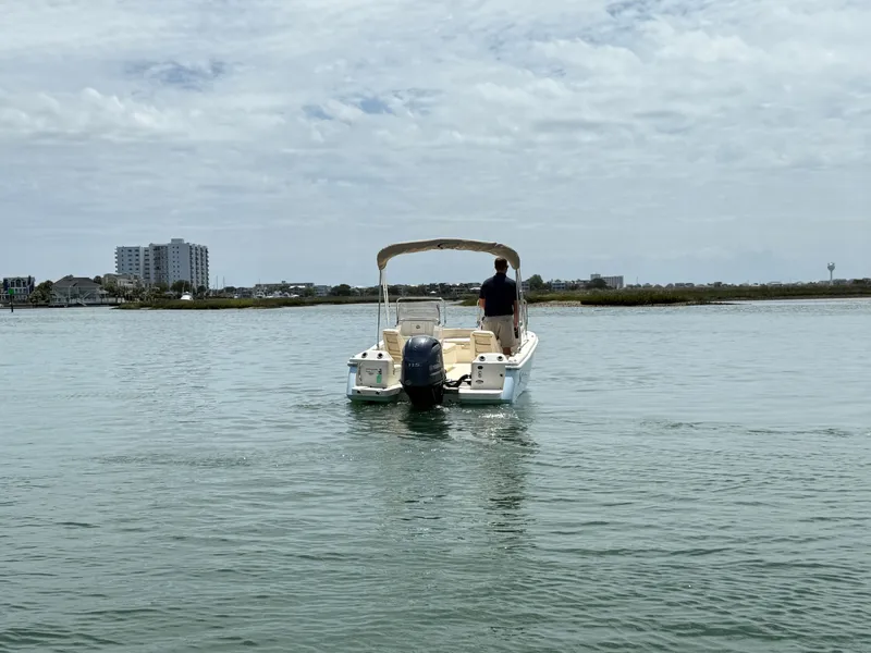 Slide: The Image of Scout 188 Sport Dorado 2026 on calm water with cityscape in background. - 1