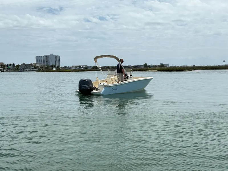 Slide: The Image of Scout 188 Sport Dorado 2026 on calm water with driver. - 2