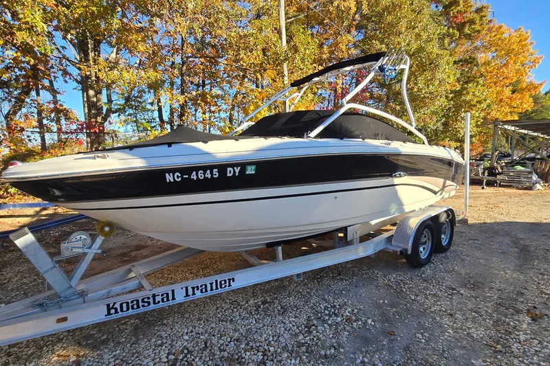 The Image of 2002 Sea Ray 220 Bow Rider on trailer, surrounded by autumn trees. - 0