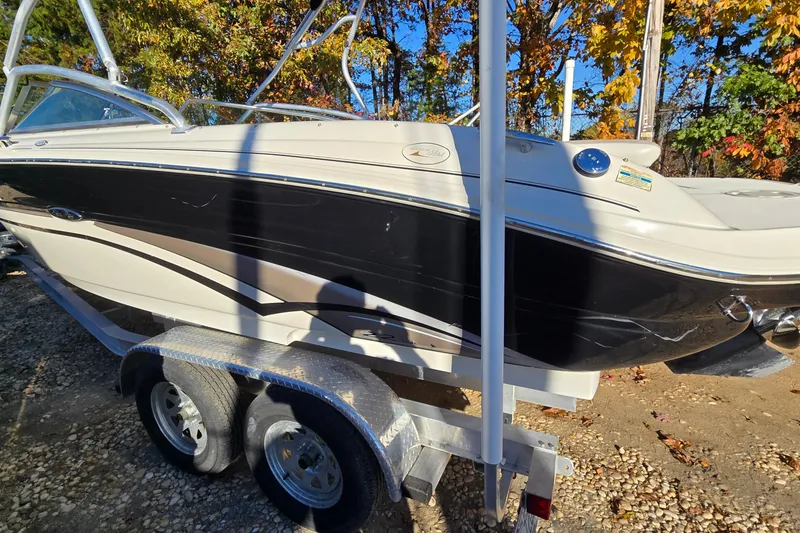 Slide: The Image of 2002 Sea Ray 220 Bow Rider on trailer, surrounded by autumn foliage. - 10