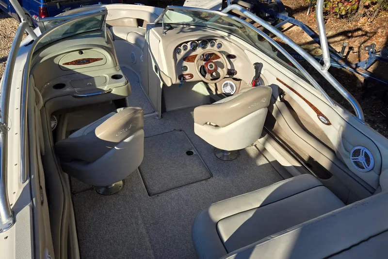 Slide: The Image of 2002 Sea Ray 220 Bow Rider interior with beige seating and modern dashboard. - 13