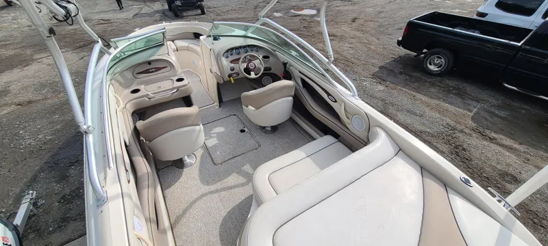 Slide: The Image of 2002 Sea Ray 220 Bow Rider interior with beige seating and steering wheel. - 31