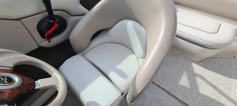 Slide: The Image of Interior of 2002 Sea Ray 220 Bow Rider boat with beige seating and steering wheel. - 36