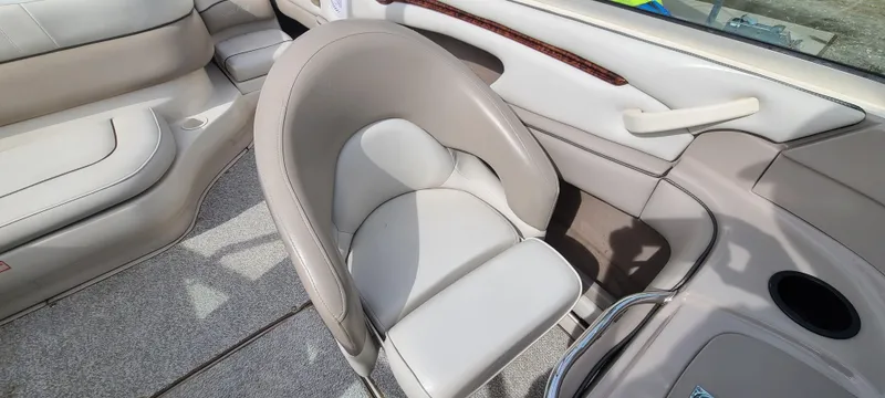 Slide: The Image of 2002 Sea Ray 220 Bow Rider interior with beige seating and cup holder. - 39