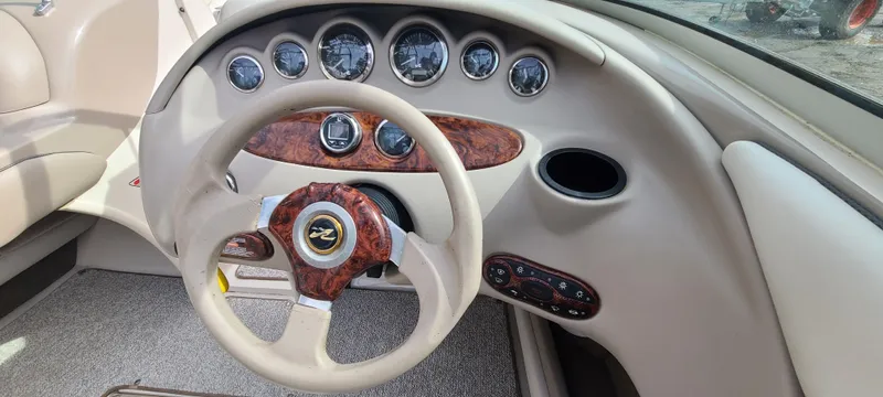 Slide: The Image of 2002 Sea Ray 220 Bow Rider dashboard with wood accents and multiple gauges. - 42