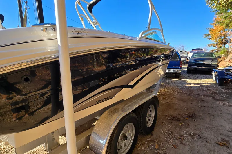 Slide: The Image of 2002 Sea Ray 220 Bow Rider on trailer, parked outdoors under clear blue sky. - 7