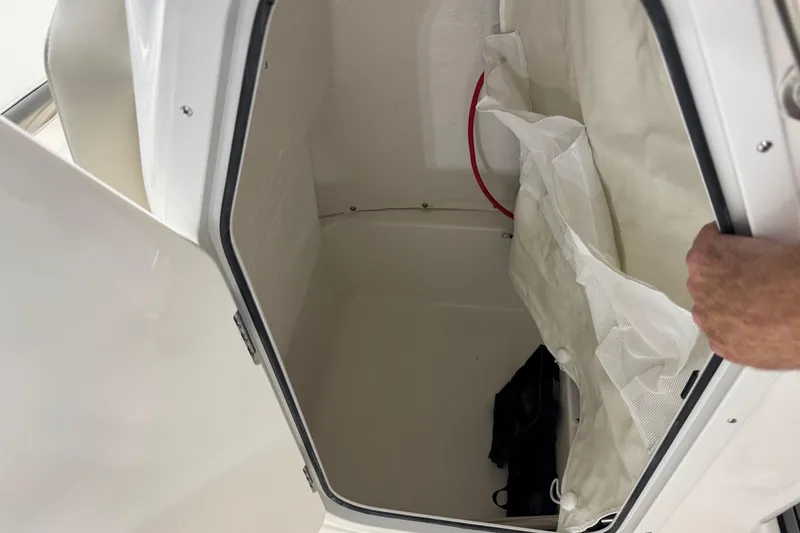 Slide: The Image of Interior storage compartment of 2026 Key West 189 FS boat, featuring white walls and netting. - 6
