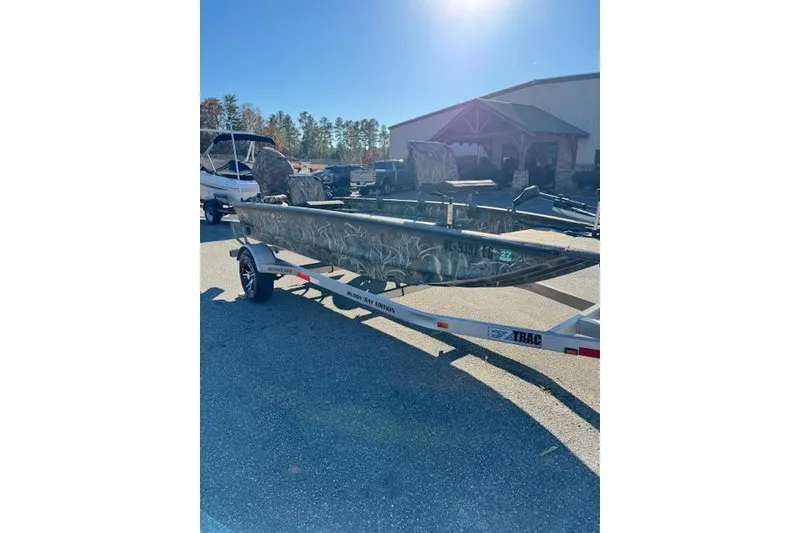 Slide: The Image of 2018 War Eagle 750 Gladiator boat on trailer, camo design, parked outdoors. - 3