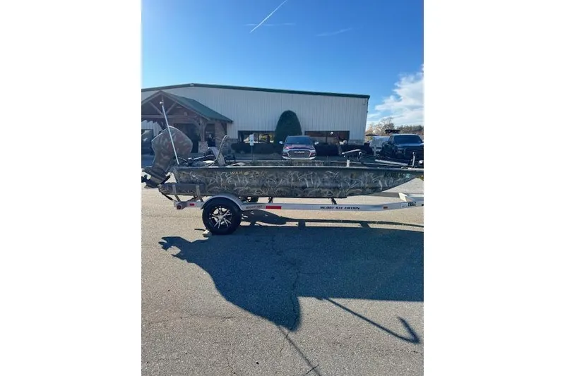 Slide: The Image of 2018 War Eagle 750 Gladiator boat on trailer, parked outside a building. - 4
