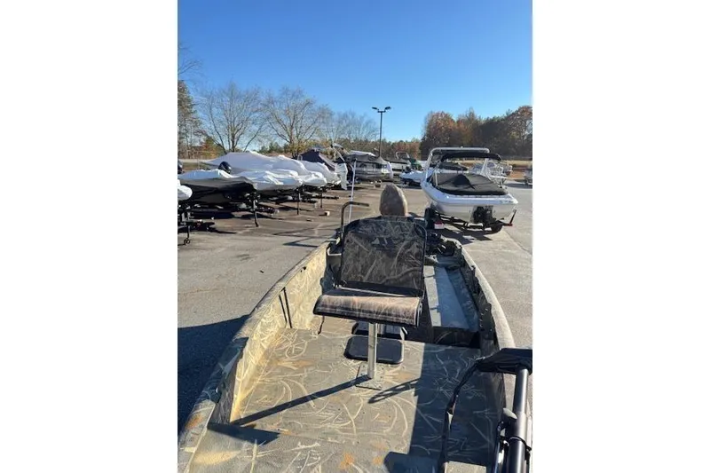 Slide: The Image of 2018 War Eagle 750 Gladiator boat with camouflage seating, parked outdoors. - 7