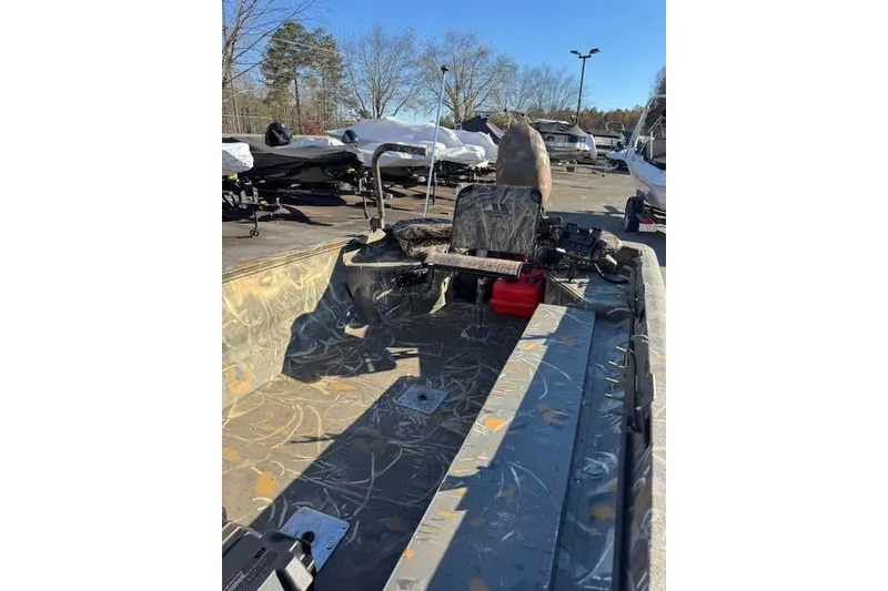 Slide: The Image of 2018 War Eagle 750 Gladiator boat interior with camouflage design, parked outdoors. - 8
