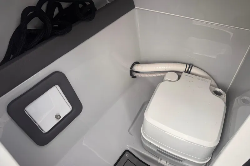 Slide: The Image of 2020 Rinker Q3 OB boat interior with portable toilet and storage compartment. - 17