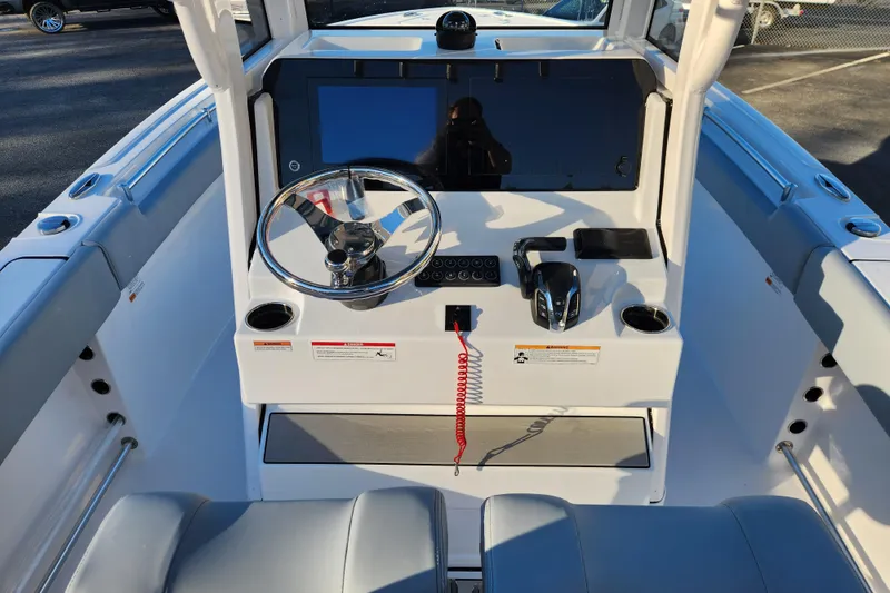 Slide: The Image of 2026 Sportsman Heritage 231 Center Console boat dashboard with steering wheel and controls. - 14