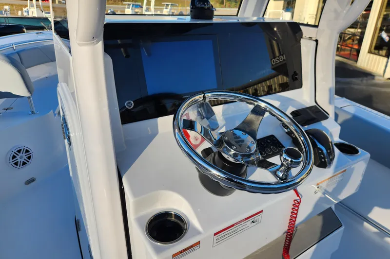 Slide: The Image of 2026 Sportsman Heritage 231 Center Console boat dashboard with steering wheel and controls. - 16