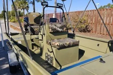 Slide: The Image of 2021 Lowe Roughneck 1860CC boat on trailer, parked outdoors with canopy and seating. - 1