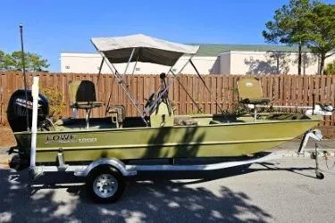 Slide: The Image of 2021 Lowe Roughneck 1860CC boat on trailer, featuring canopy and motor, parked outdoors. - 10