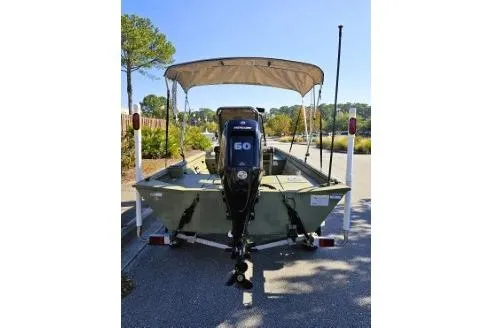 Slide: The Image of 2021 Lowe Roughneck 1860CC boat with canopy and 60HP motor, parked outdoors. - 12