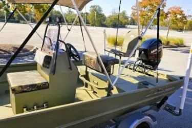 Slide: The Image of 2021 Lowe Roughneck 1860CC boat with trolling motor, parked near wooden fence. - 7