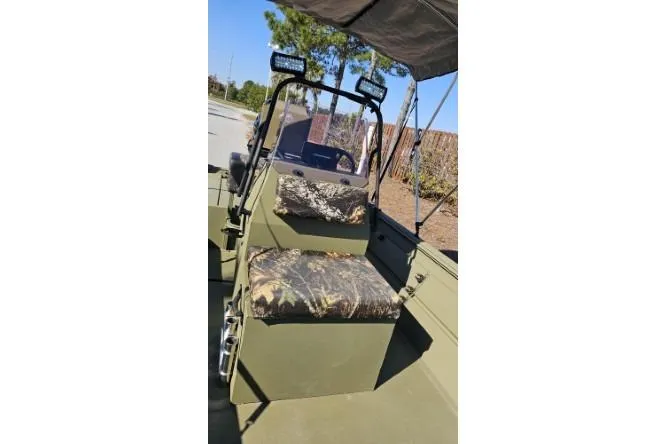 Slide: The Image of 2021 Lowe Roughneck 1860CC boat with canopy, parked outdoors, showcasing interior and motor. - 8