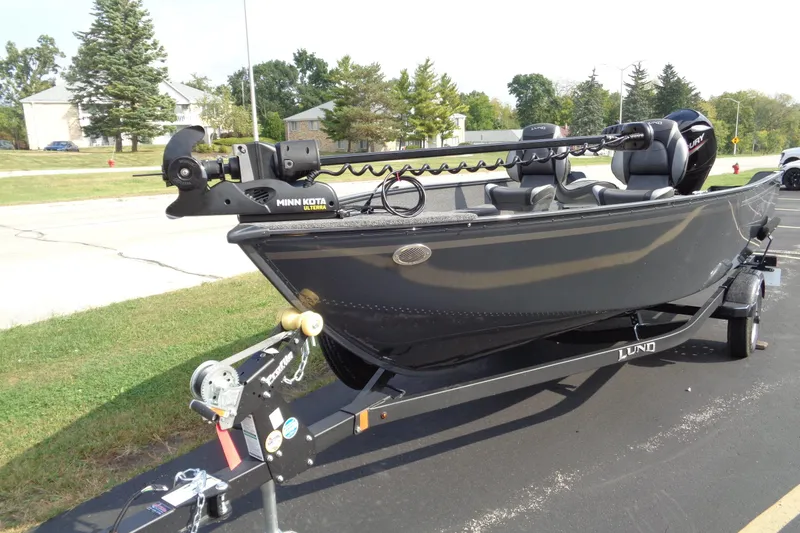 Slide: The Image of 2026 Lund 1650 Angler Tiller boat on trailer, featuring Minn Kota motor. - 10