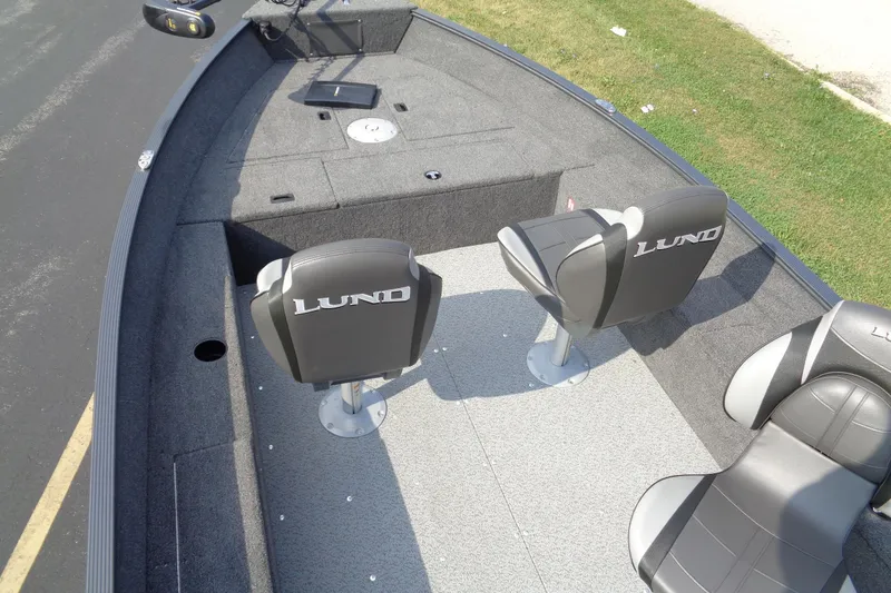 Slide: The Image of 2026 Lund 1650 Angler Tiller boat interior with seating and carpeted deck. - 15