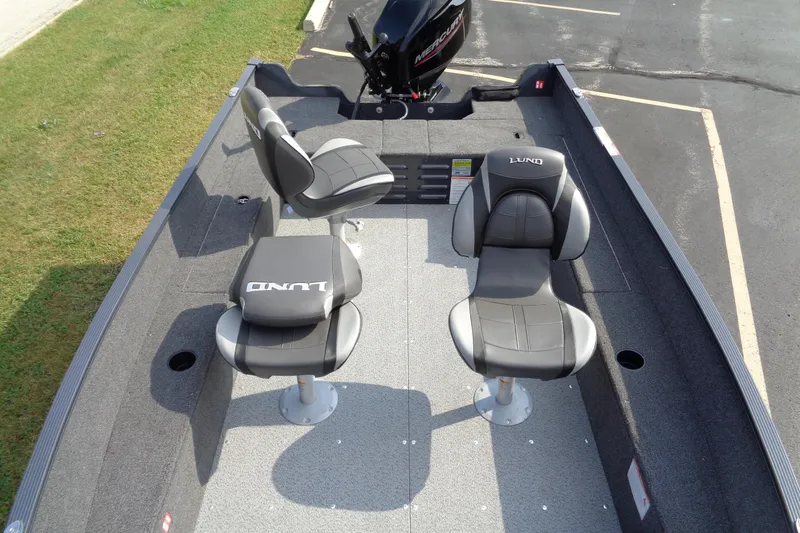 Slide: The Image of 2026 Lund 1650 Angler Tiller boat interior with two swivel seats and motor. - 16