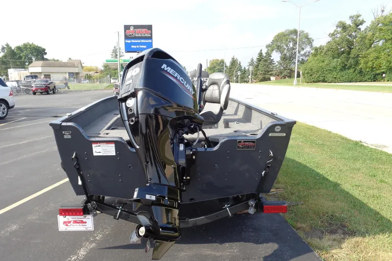 Slide: The Image of 2026 Lund 1650 Angler Tiller boat with Mercury outboard motor, parked outdoors. - 4