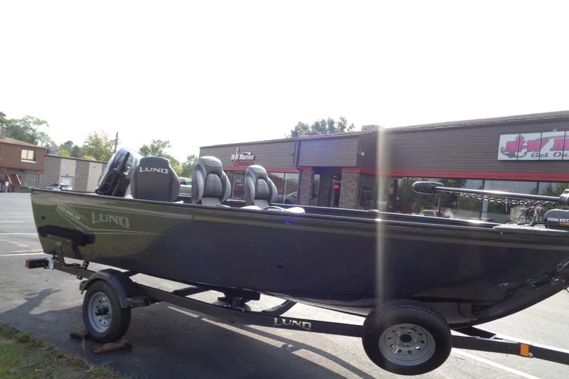 Slide: The Image of 2026 Lund 1650 Angler Tiller boat on trailer outside marine store. - 8