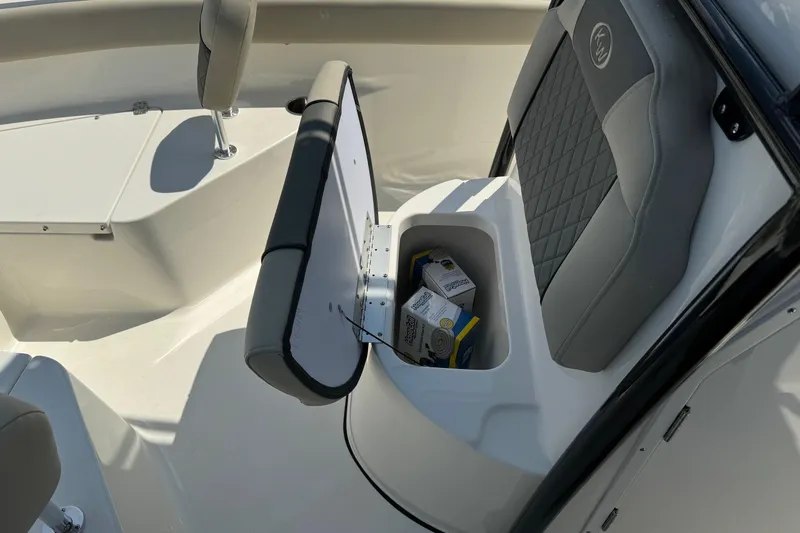 Slide: The Image of 2025 Key West 203 FS boat interior with open storage compartment and cushioned seating. - 13