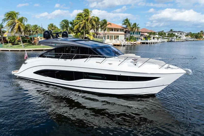 Slide: The Image of 2021 Princess V55 yacht cruising on a sunny day near waterfront homes. - 10