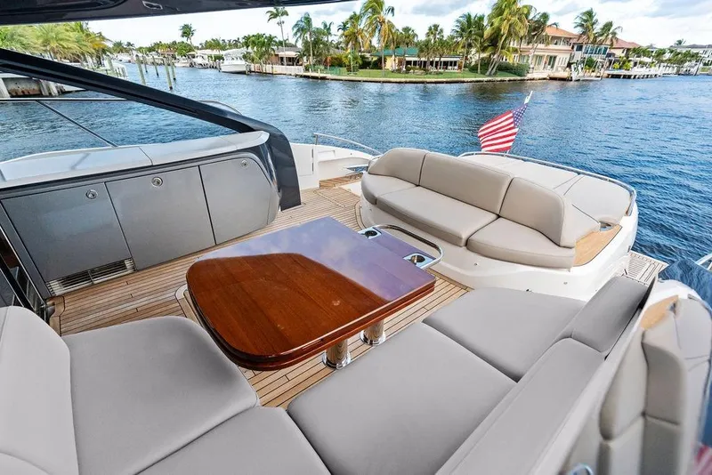 Slide: The Image of Luxurious 2021 Princess V55 yacht deck with elegant seating and scenic waterfront view. - 15