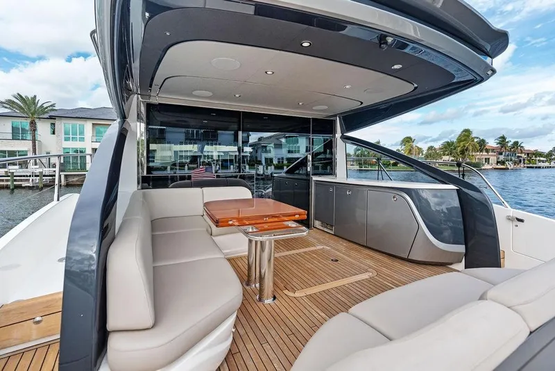 Slide: The Image of Luxurious 2021 Princess V55 yacht with elegant seating and sleek design on a sunny waterfront. - 17
