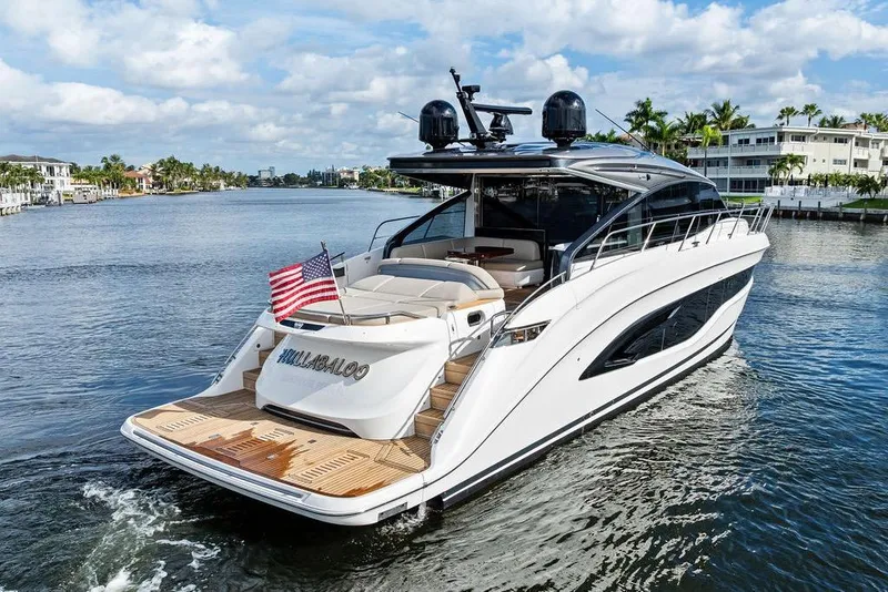 Slide: The Image of Luxurious 2021 Princess V55 yacht cruising on a scenic waterway, featuring sleek design and American flag. - 4