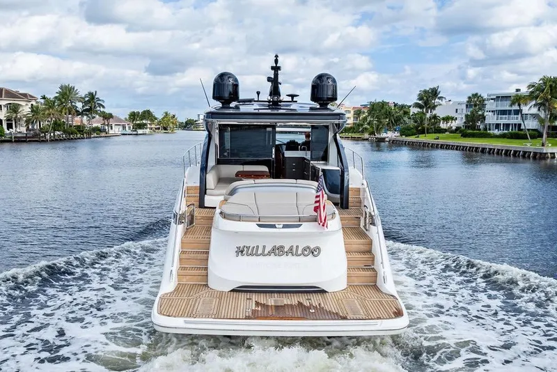 Slide: The Image of 2021 Princess V55 yacht cruising on a scenic waterway with palm trees and luxury homes. - 5