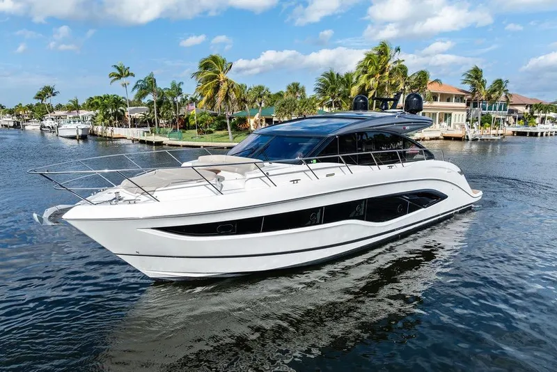 Slide: The Image of Luxury 2021 Princess V55 yacht cruising on a scenic waterway with palm trees. - 7