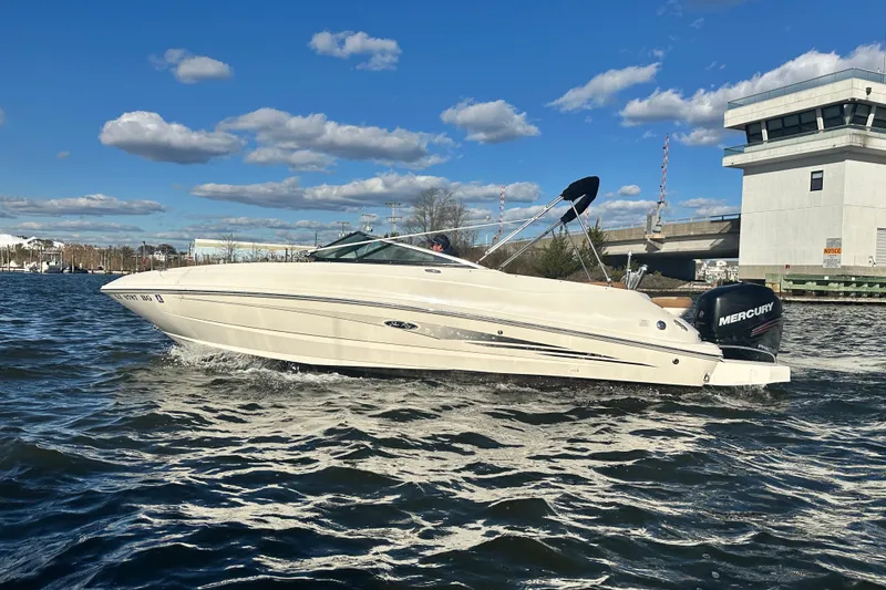 Slide: The Image of 2014 Sea Ray 240 Sundeck Outboard cruising on a sunny day near a bridge. - 0