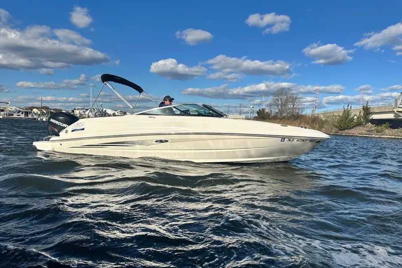 Slide: The Image of 2014 Sea Ray 240 Sundeck Outboard on water under blue sky. - 10