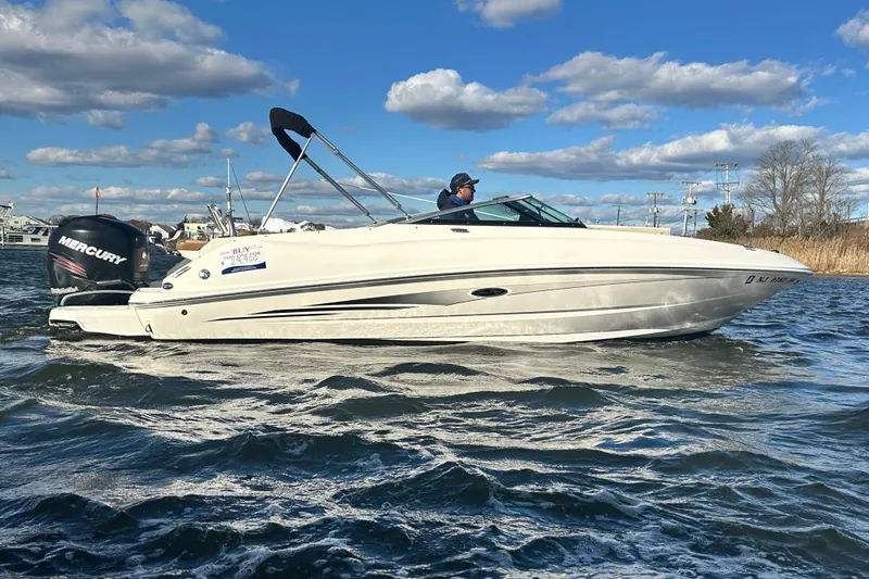 Slide: The Image of 2014 Sea Ray 240 Sundeck Outboard boat cruising on a sunny day with clear skies. - 11