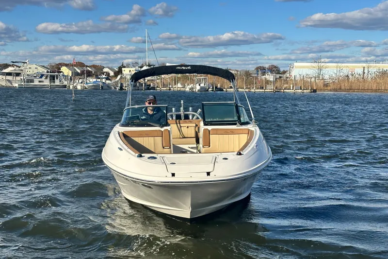 Slide: The Image of 2014 Sea Ray 240 Sundeck Outboard on water, clear sky, marina background. - 13