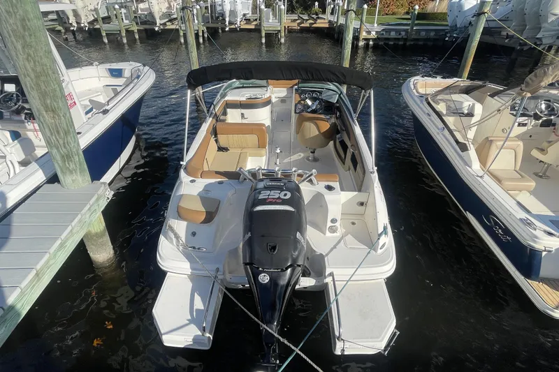 Slide: The Image of 2014 Sea Ray 240 Sundeck Outboard boat docked, featuring a powerful 250 HP engine. - 15