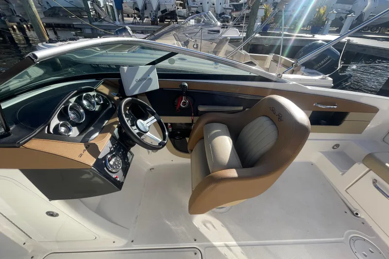 Slide: The Image of 2014 Sea Ray 240 Sundeck Outboard cockpit with steering wheel and Garmin navigation system. - 17