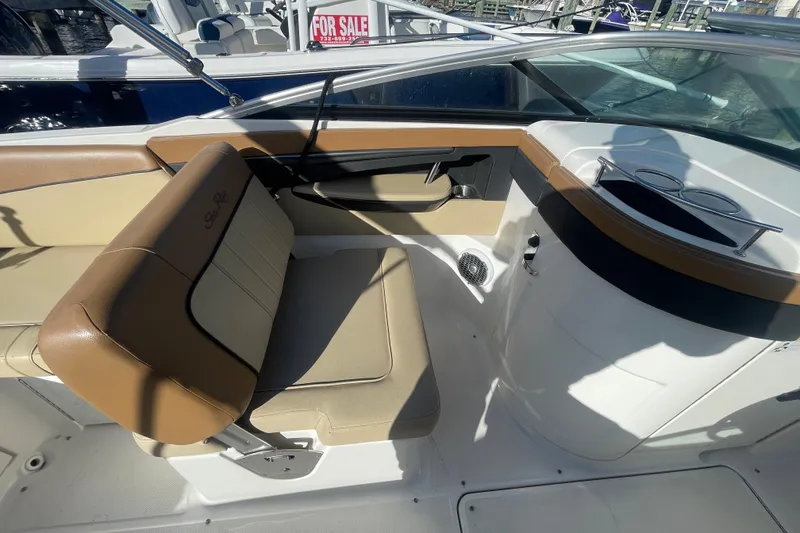 Slide: The Image of 2014 Sea Ray 240 Sundeck Outboard interior with tan seating and cup holders. - 18