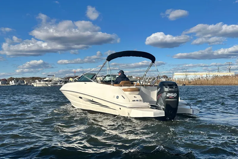 Slide: The Image of 2014 Sea Ray 240 Sundeck Outboard cruising on a sunny day with blue skies. - 2
