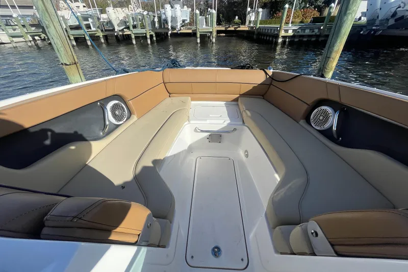Slide: The Image of 2014 Sea Ray 240 Sundeck Outboard interior with tan seating and speakers. - 23