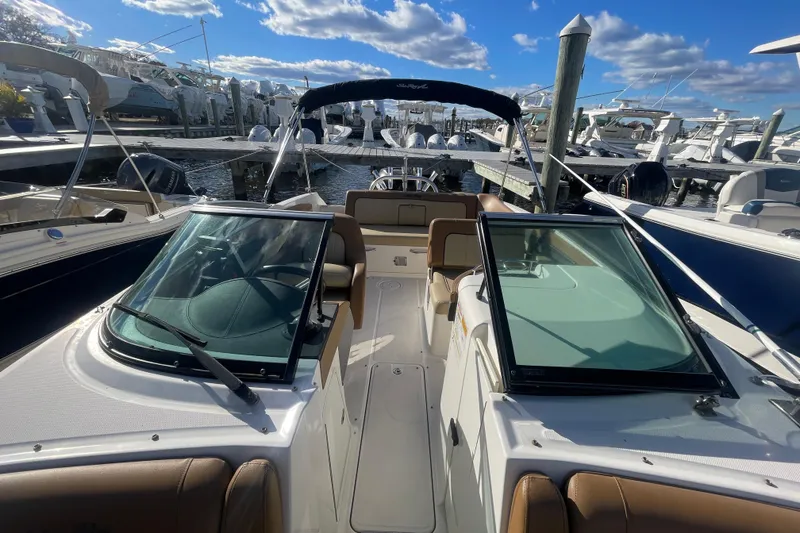 Slide: The Image of 2014 Sea Ray 240 Sundeck Outboard boat docked under a clear blue sky. - 24