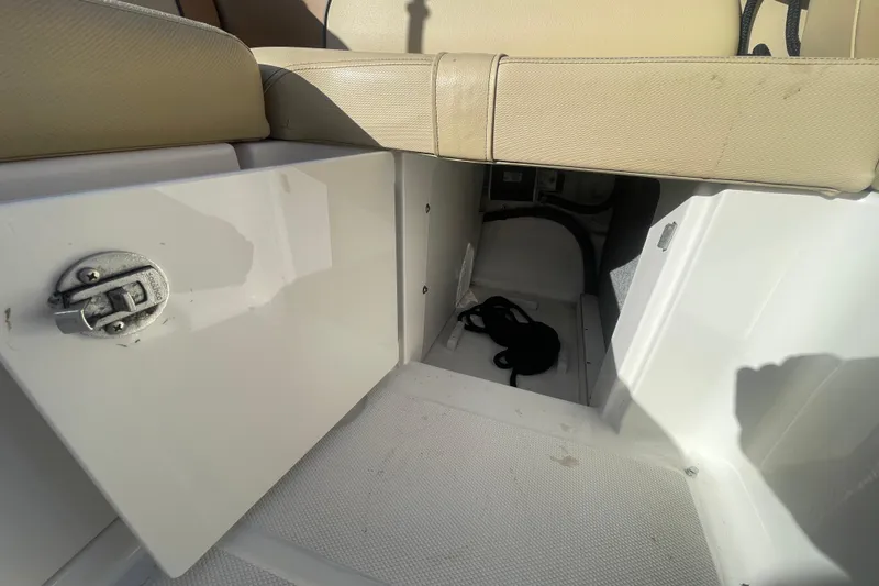 Slide: The Image of 2014 Sea Ray 240 Sundeck Outboard storage compartment with open hatch and beige seating. - 27