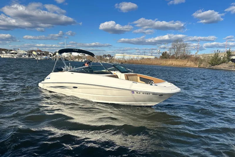 Slide: The Image of 2014 Sea Ray 240 Sundeck Outboard cruising on a sunny day with blue skies. - 9